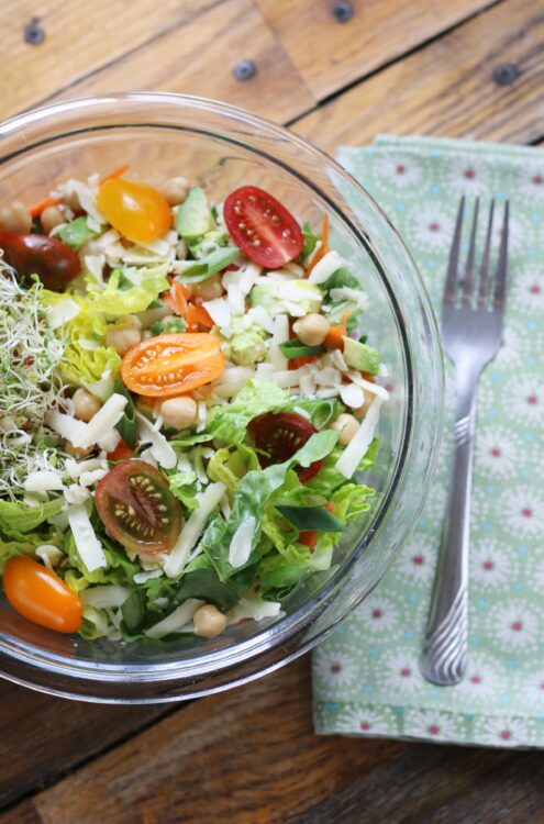 Salad with greens, sprouts, tomatoes, and cheese.