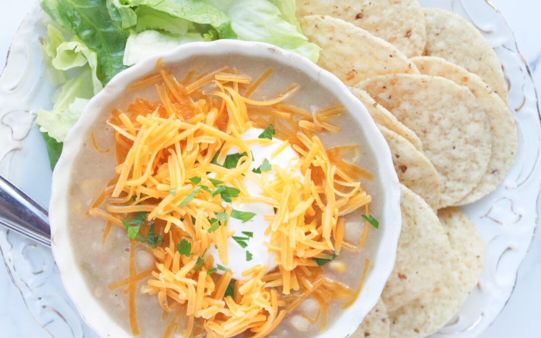 White bean chili topped with sour cream, cilantro, and shredded cheddar cheese